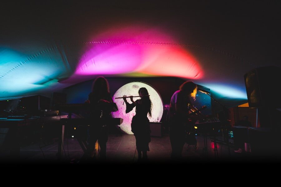 A silhouette of a flute player on stage at boomerang festival