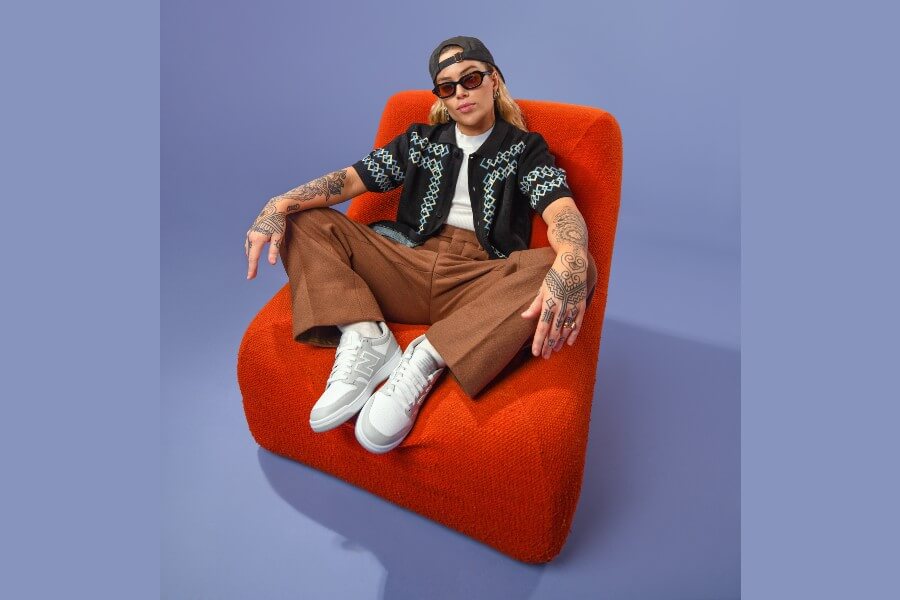 Tash Sultana sitting on a red couch