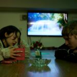 Brutalismus 3000 at table looking at each other. Photo by Joseph Kadow.