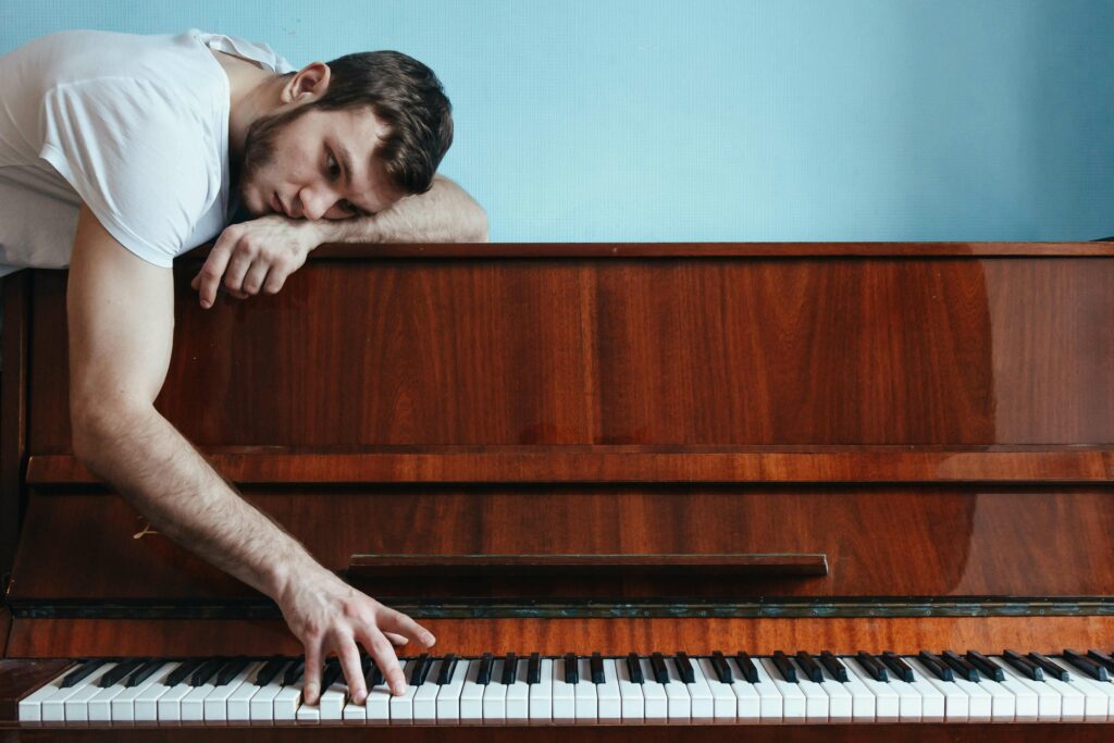 Sad musician playing piano dealing with rejection