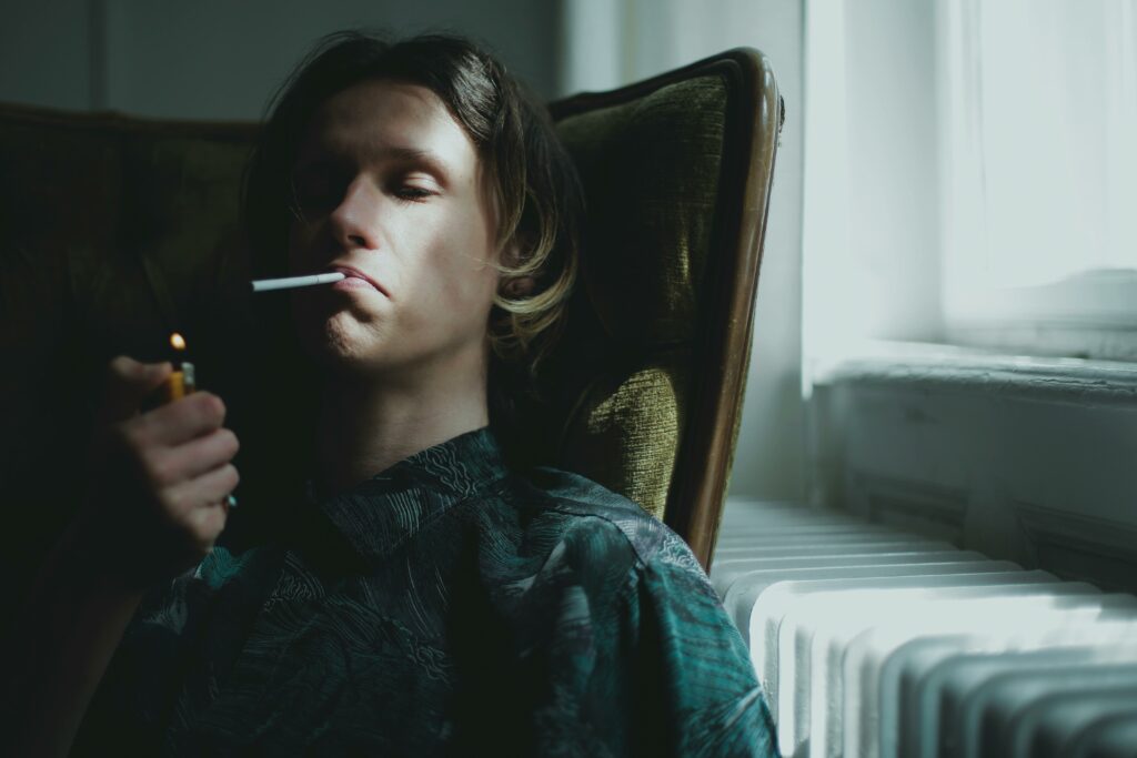 Man lighting up a joint in chair at home