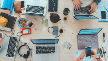 View above a communal table with people working on laptops