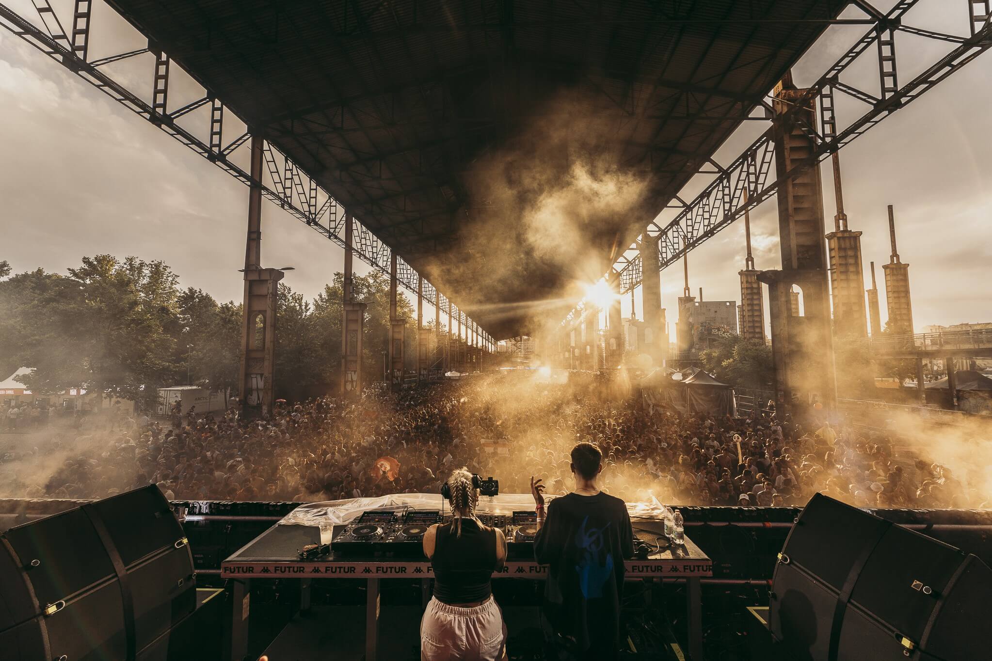 DJs playing at Kappa Futur in 2024 with light shining through clouds of smoke.