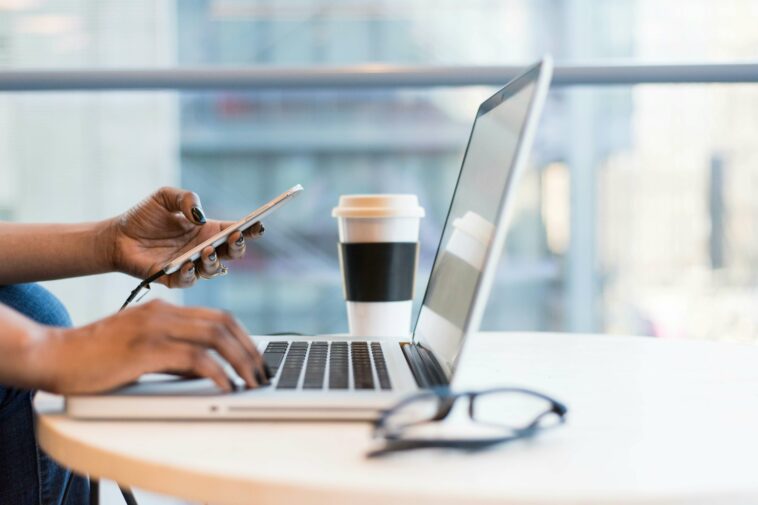 Worker on their laptop with glasses and coffee in the image