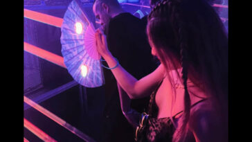 woman with braids fighting lazers at a festival