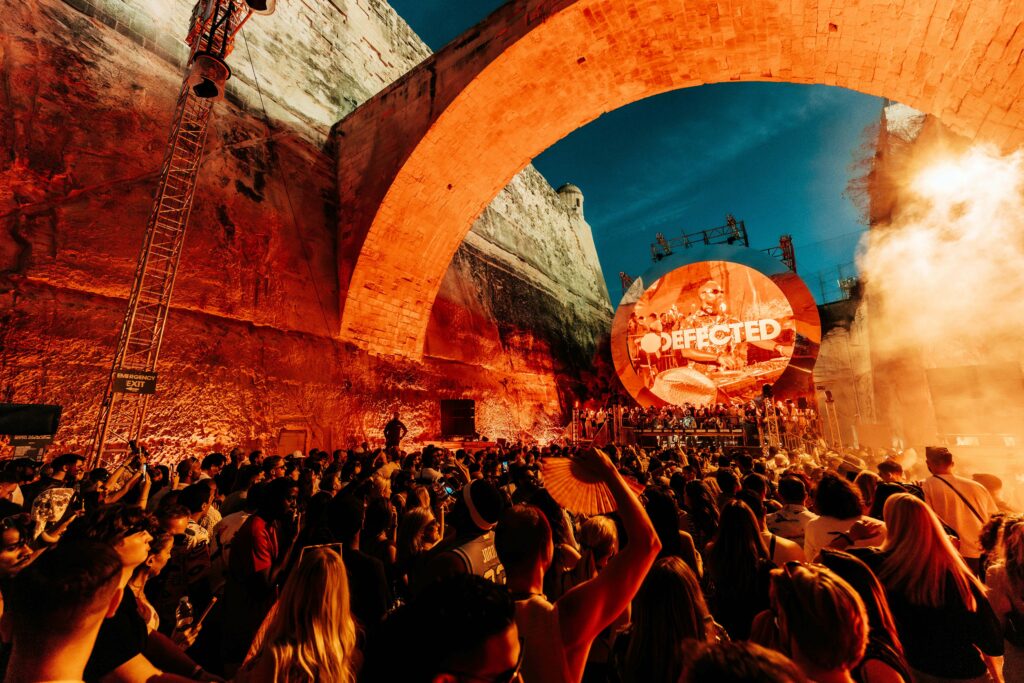 Image from Defected Festival in 2024 from the battlements of Valletta with orange lighting.