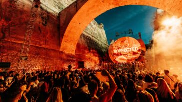 DJ playing in front of the Valetta battlements with orange lighting.