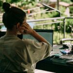 Remote worker working on a laptop with greenery in the background