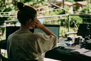 Remote worker working on a laptop with greenery in the background