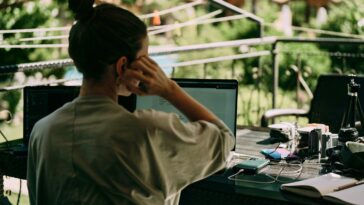 Remote worker working on a laptop with greenery in the background