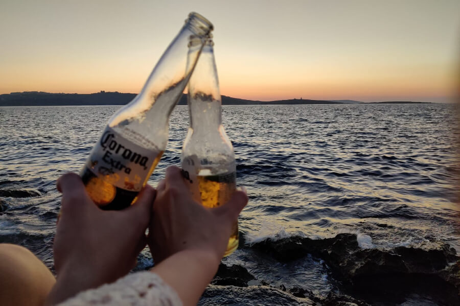 beers clinking at the beach