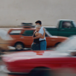Couple hugging as cars drive past in a blur