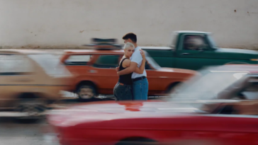 Couple hugging as cars drive past in a blur