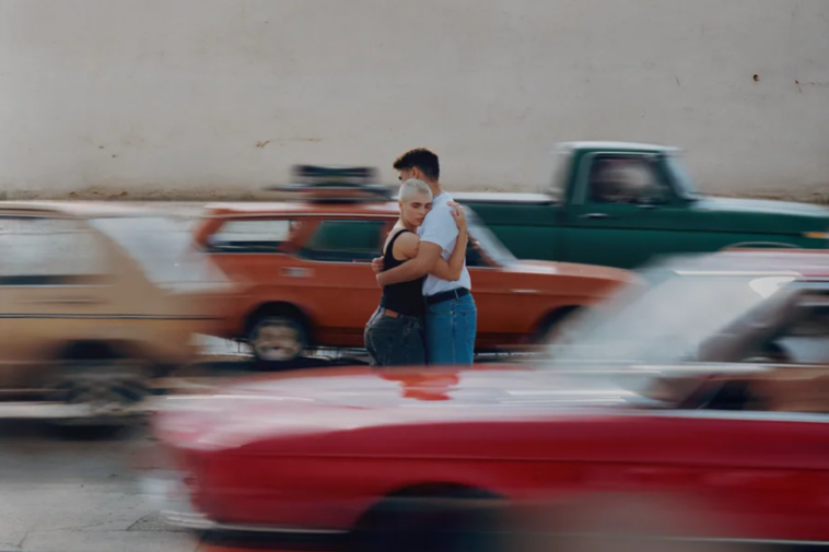 Couple hugging as cars drive past in a blur