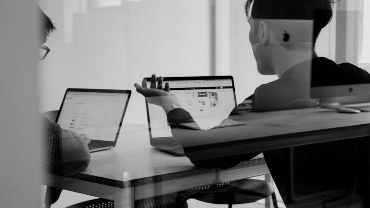 Black and white image of people working in a conference room.