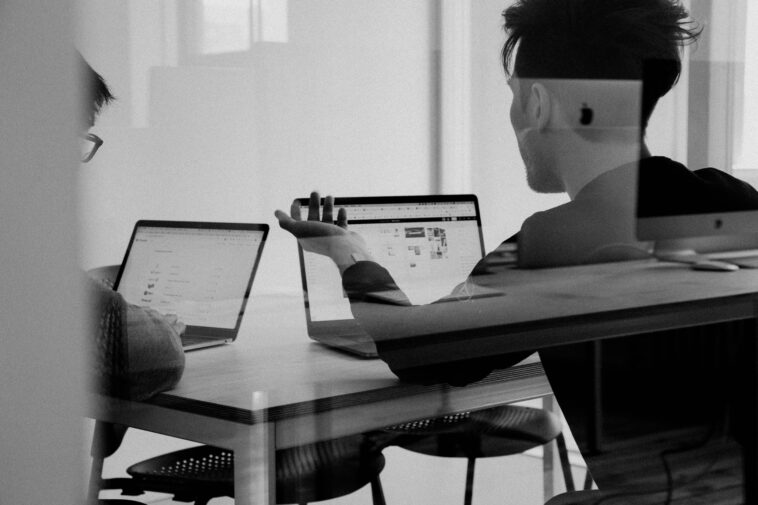Black and white image of people working in a conference room.